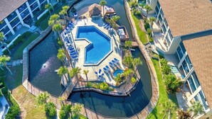 An aerial view of a hotel with a central swimming pool, surrounded by lounge chairs and palm trees. - Fantastic views from this delightful unit! (St. Augustine)