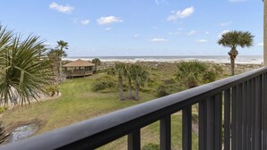 A view from a balcony overlooking a beach with palm trees, a gazebo, and the ocean. - Fantastic views from this delightful unit! (St. Augustine)