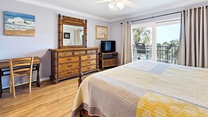 Ein Hotelzimmer mit Bett, Kommode, Fernseher, Sessel und einem Balkon mit Blick.
