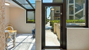 L'ingresso di un hotel con una porta in vetro, una sala da pranzo con tavolo e sedie, e vista sulla facciata dell'edificio.