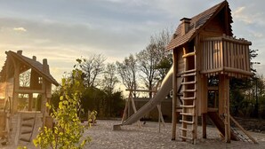 A playground with wooden play structures including a slide and a climbing ladder. - Family Home Near Lake, Beach and Dunes (Noordwijkerhout)