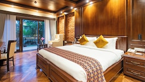 Un dormitorio espacioso con una cama grande, cabecera de madera y vistas a través de la puerta de cristal.