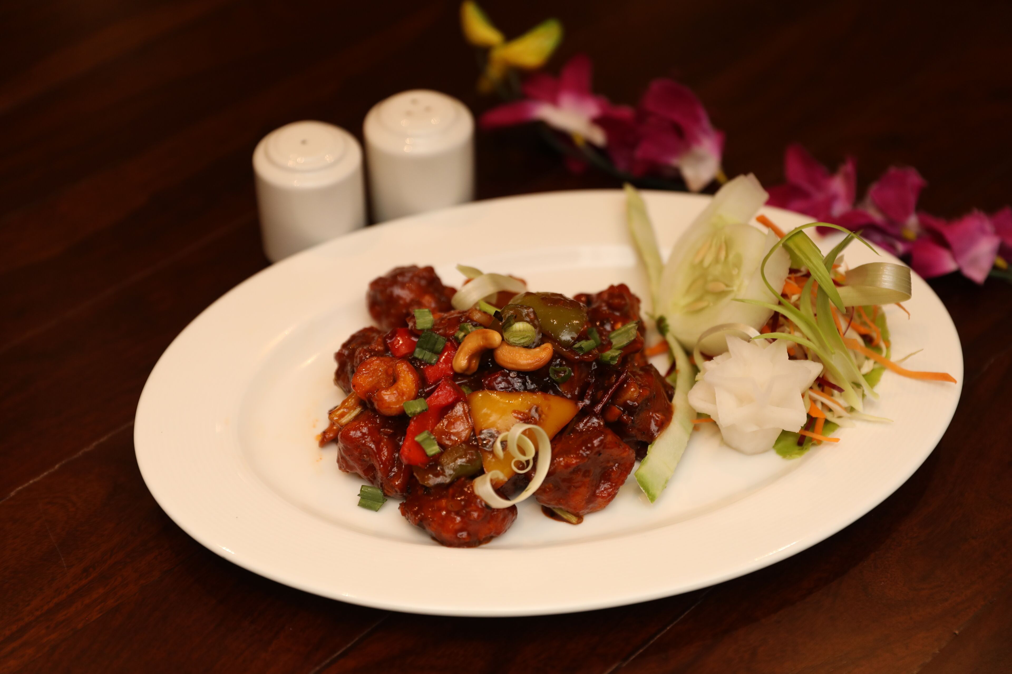 Un plato de comida con ensalada y flores decorativas.