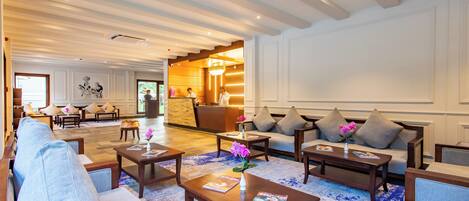 A spacious lobby with a reception desk, sofas, and a coffee table.