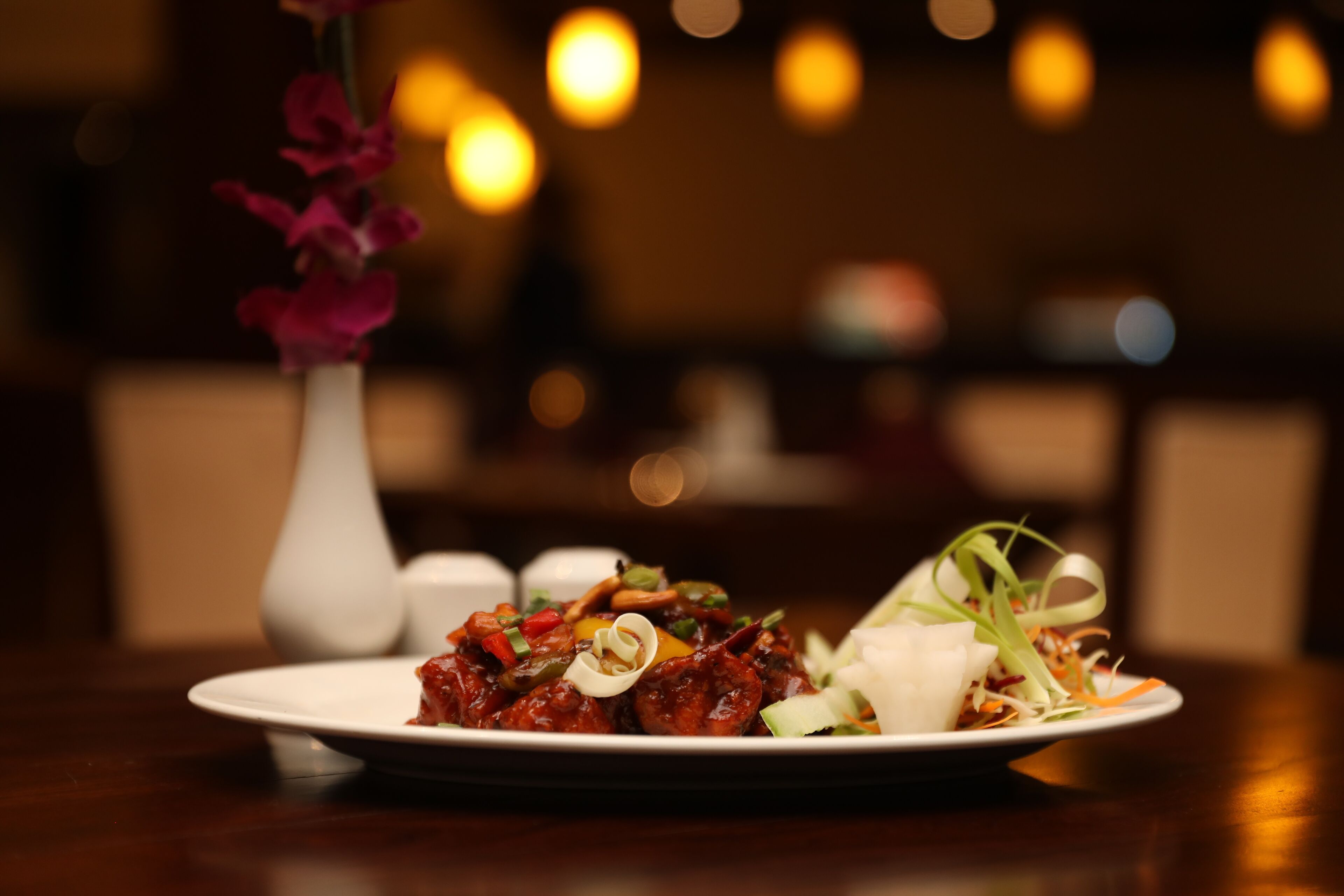 A plate of food with a decorative vase in the background.