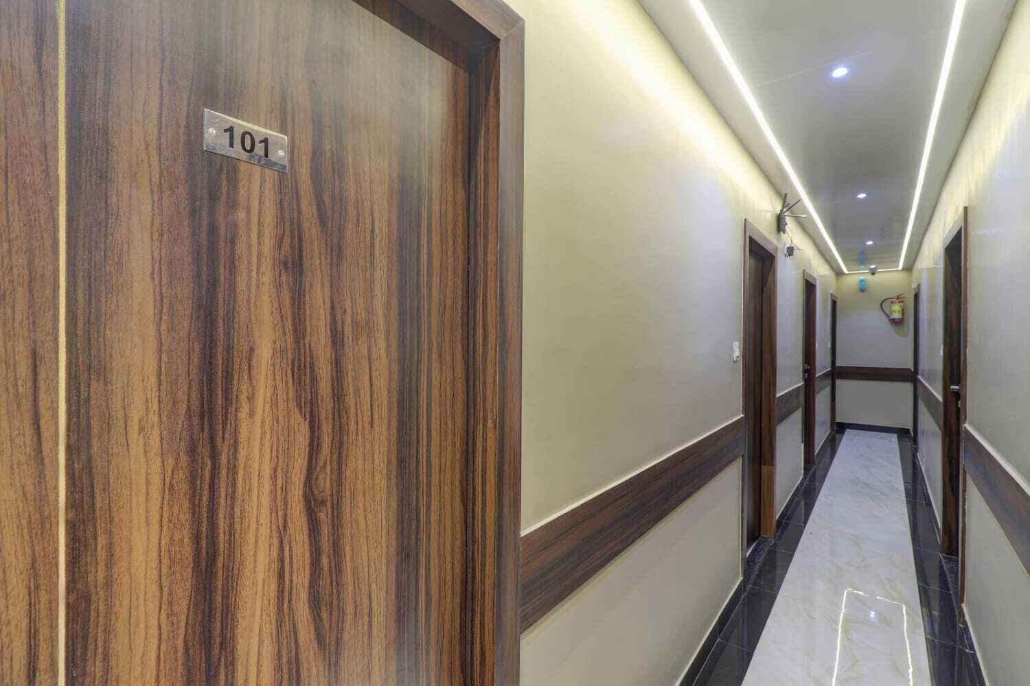 A hotel hallway with wooden doors, numbered 101, and a tiled floor.