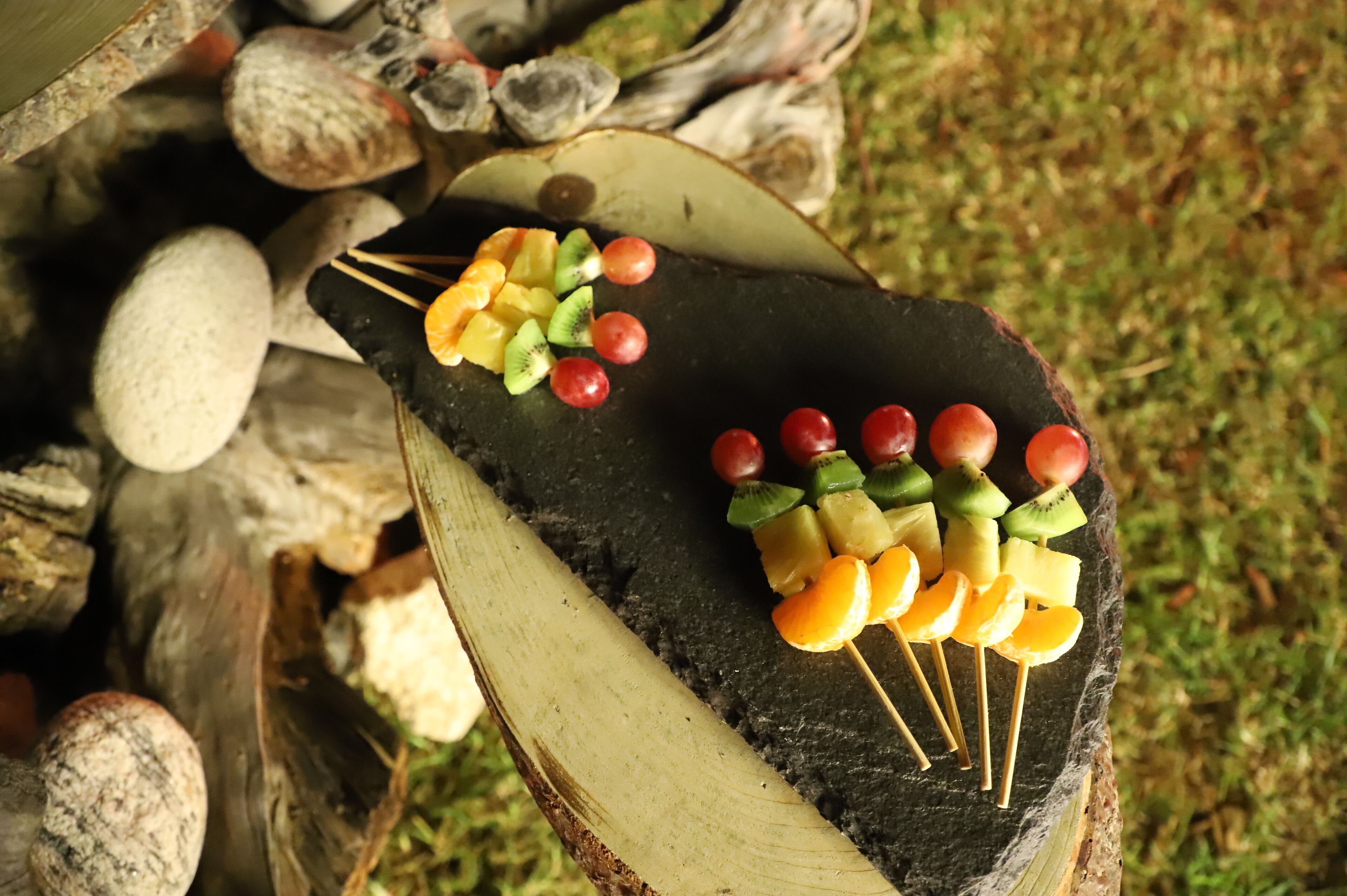A wooden surface with fruit skewers.
