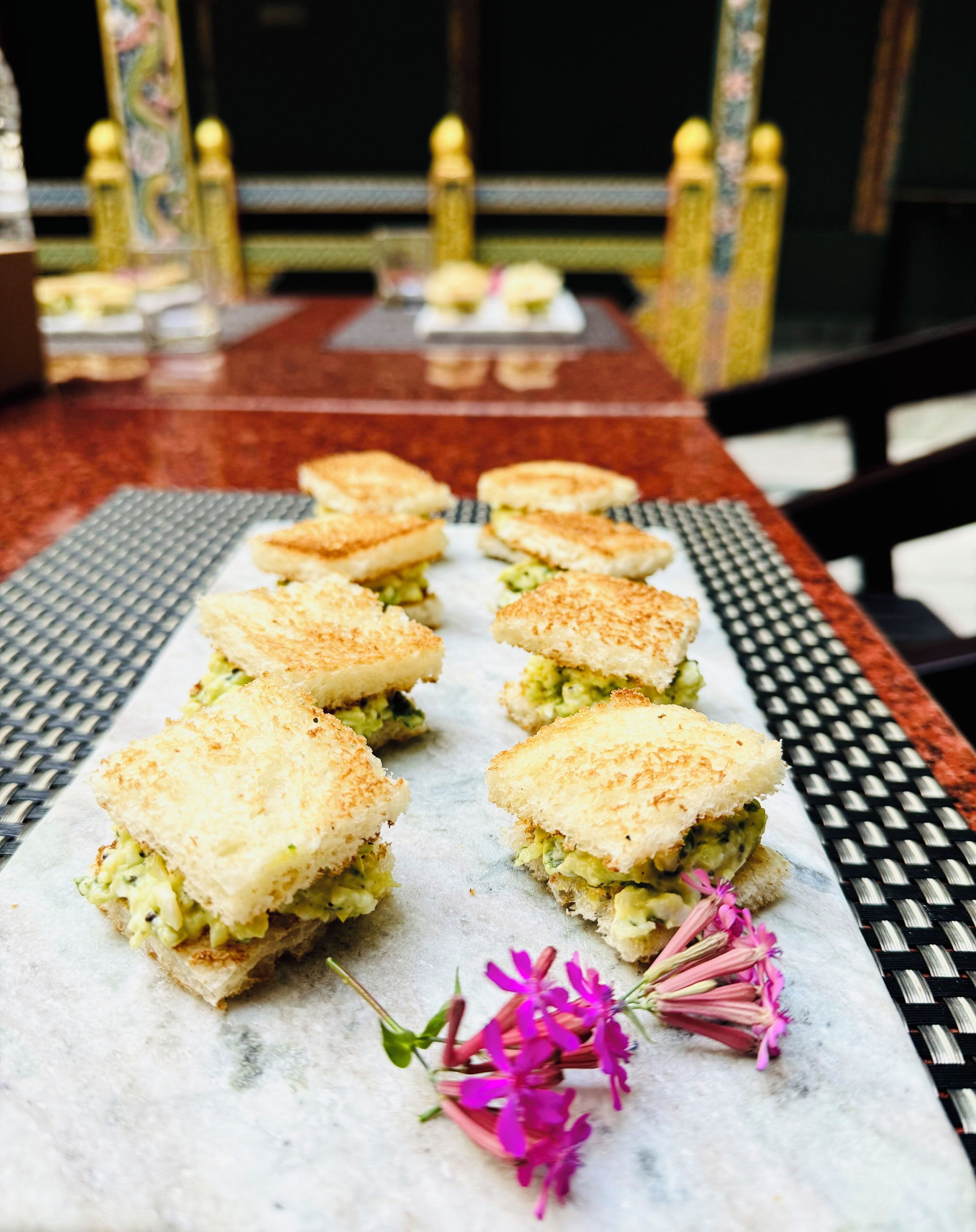 Une table avec des sandwichs et des fleurs.