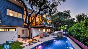A modern two-story house with a swimming pool, outdoor seating, and a large tree in the yard. - Above Capitol View I Skyline Views I Pool/Spa I Events I Weddings (Austin)