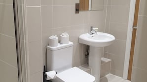 Une salle de bain moderne équipée de toilettes, d’un bidet et d’un lavabo.