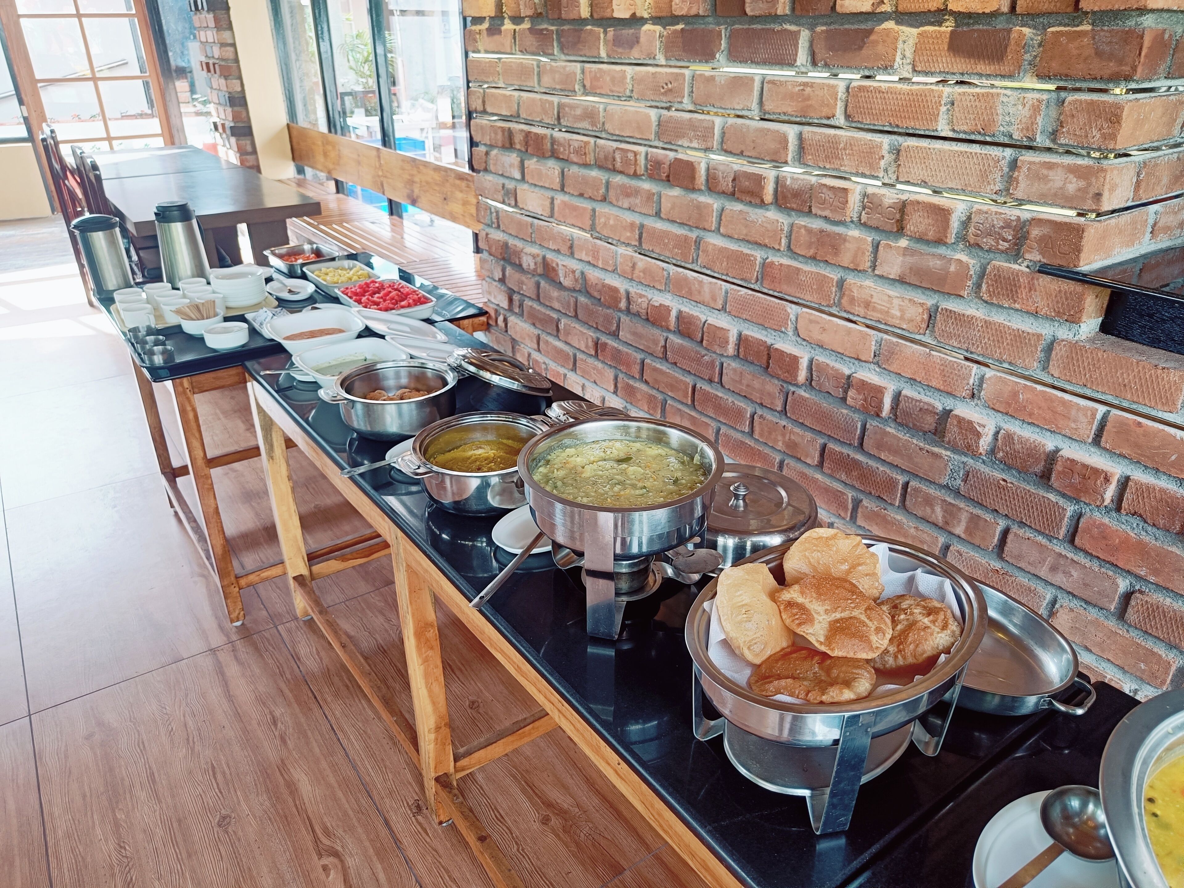 A buffet setup with various food items and containers on a long table.