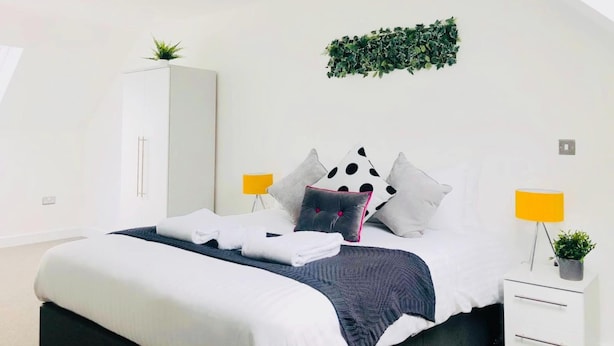 A modern bedroom with a bed, white wardrobe, and two bedside tables with lamps. - Peak District One King Bedroom Haven by Belvilla (Sheffield)