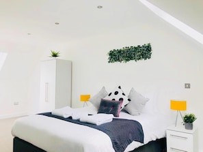 A modern bedroom with a bed, white wardrobe, and two bedside tables with lamps. - Peak District One King Bedroom Haven by Belvilla (Sheffield)