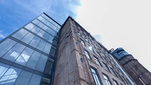 A modern building with a glass facade and a brick structure. - Two-bedroom by Leeds Art Gallery by Belvilla (Leeds)