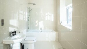 A modern bathroom with a glass-enclosed shower, a bathtub, a toilet, and a sink. - City Chic Christchurch 2BR Apartments by Sojo Stay (Ipswich)