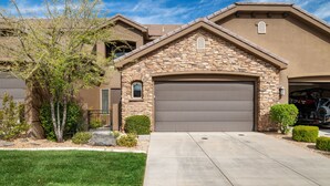 A two-story house with a stone facade, a garage, and a well-maintained lawn. - Zion's Edge: Two Pools and Hot Tubs, Clubhouse Gym (Washington)