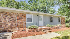 A single-story house with a brick facade, a front door, and a small front yard with mulch and plants. - Tallahassee Home w/ Yard < 2 Mi to FSU Campus (Tallahassee)