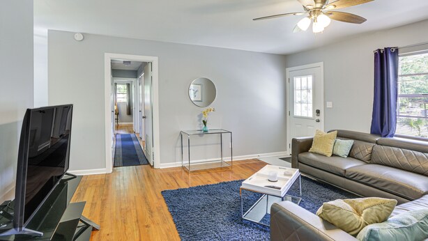 A modern living room with a flat-screen TV, leather sofa, and a ceiling fan. - Tallahassee Home w/ Yard < 2 Mi to FSU Campus (Tallahassee)