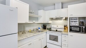 A compact kitchen with white cabinetry, a built-in oven, a microwave, and a coffee maker. - Tallahassee Home w/ Yard < 2 Mi to FSU Campus (Tallahassee)
