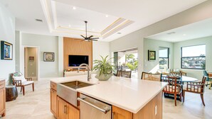 A modern kitchen with a large island, wooden cabinetry, and a built-in dishwasher. - Luxe Home in Punta Gorda w/ Pool: Canal Views! (Punta Gorda)