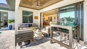 An outdoor patio area with a dining table, chairs, and a sofa. - Luxe Home in Punta Gorda w/ Pool: Canal Views! (Punta Gorda)