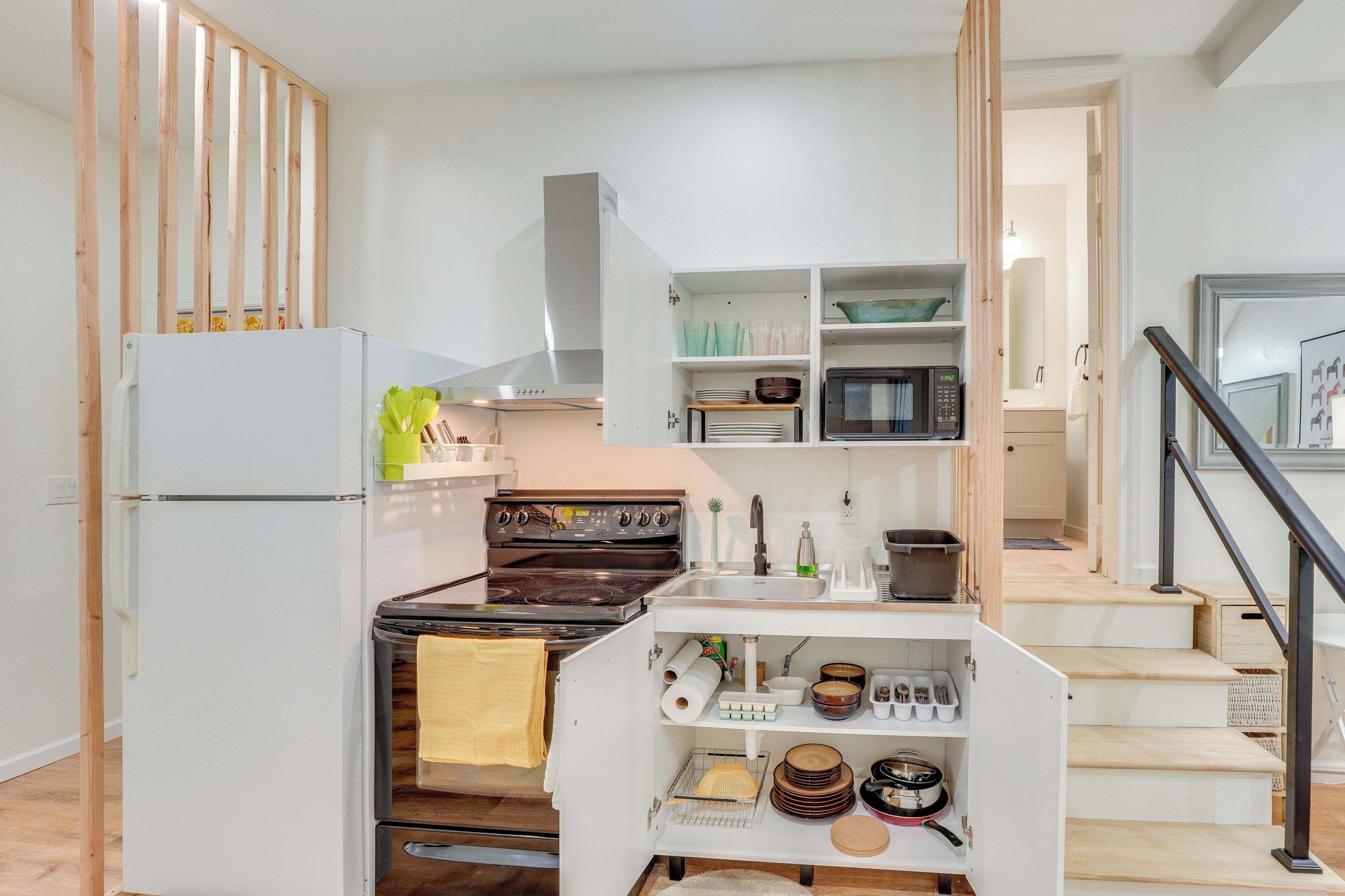 Une cuisine compacte dotée d’un four, d’un micro-ondes et d’un évier intégrés.