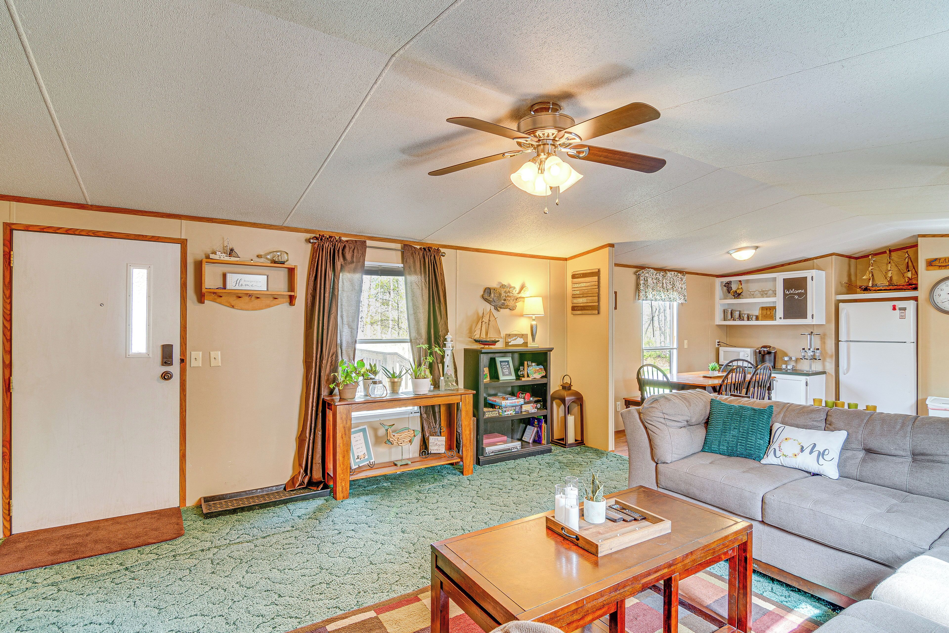 A cozy living room with a ceiling fan, a sofa, a coffee table, and a bookshelf.