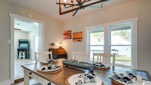 A dining area with a wooden table set for four, a fireplace, and large windows overlooking a body of water. - 'sunset Paradise' on Weiss Lake w/ Private Dock! (Centre)