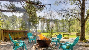 A fire pit with chairs around it, set on a gravel area with trees in the background. - Hike On-site: Georgia Tiny Home on Farm Retreat (Lithonia)
