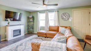 A living room with a fireplace, a sofa, a television, and a ceiling fan. - Serene Roseland Retreat Near Wintergreen Resort! (Roseland)