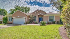 A two-story house with a garage, a front porch, and a well-maintained lawn.