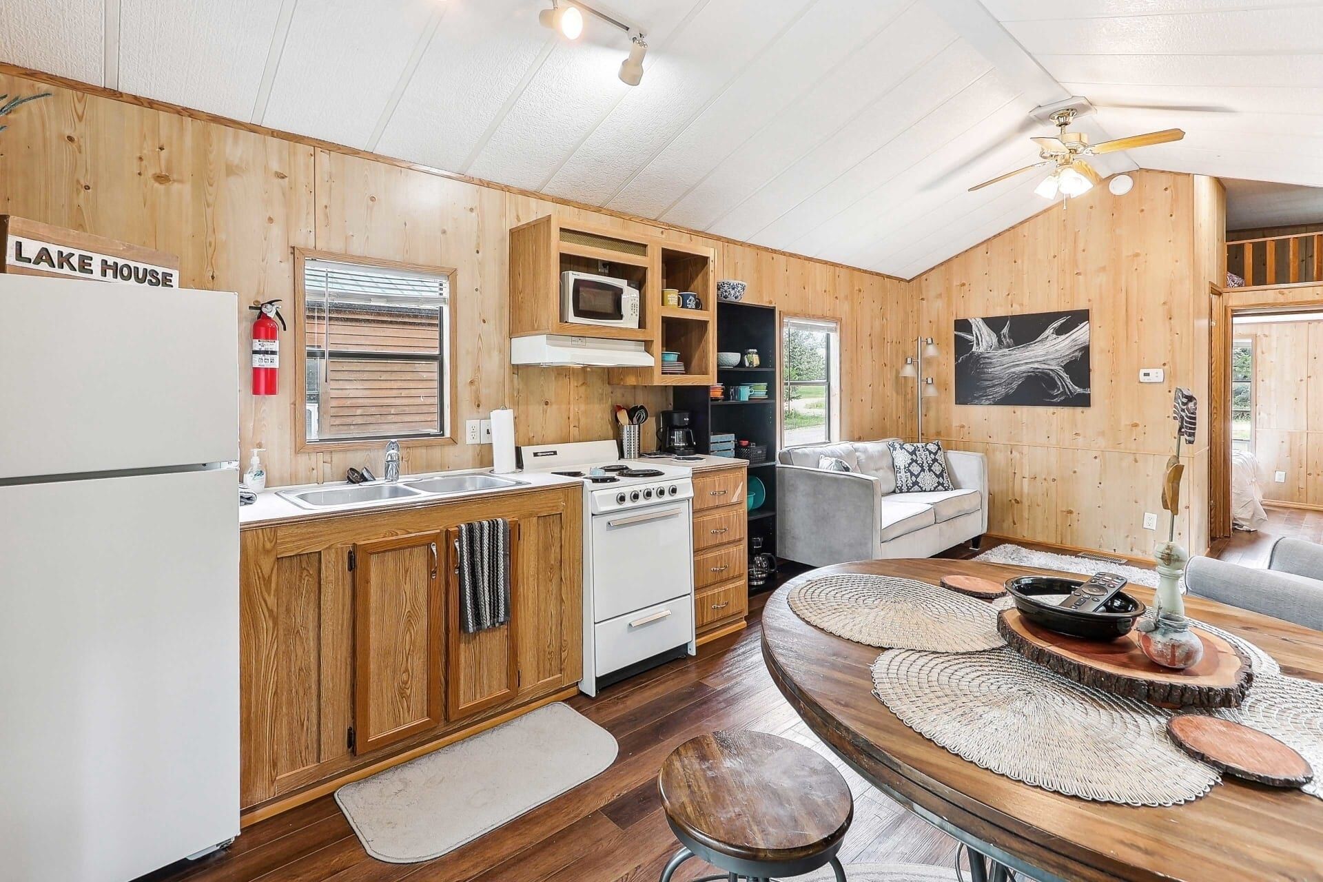 A cabin interior with a kitchen, dining area, and a living room.