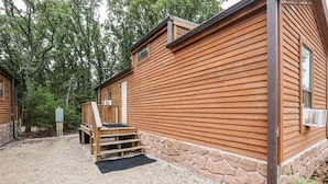 A wooden cabin with a stone foundation, a wooden deck, and a gravel driveway. - Cabin 9 ~ Toronto Lake: Fishing, Swimming & More! 1 Bedroom Cabin by RedAwning (Toronto)