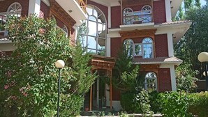A two-story brick building with large windows and a covered entrance. - Hotel Leh Residency (Leh)