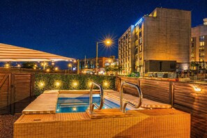 A rooftop pool with a view of a cityscape at night.