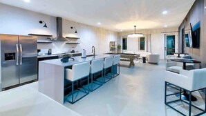 A modern kitchen with a central island, stainless steel appliances, and contemporary furniture. - New-14 Beds! Walk to broadway|Private Hot Tub/Pool (Nashville)