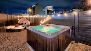 A hot tub in a backyard with a wooden fence, a lounge chair, and a pool. - New-14 Beds! Walk to broadway|Private Hot Tub/Pool (Nashville)