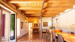 A wooden interior with a dining area, a fireplace, and a view through an open door. - Villa Gelso: your luxury villa with pool and sauna in Le Marche region (Provincia di)