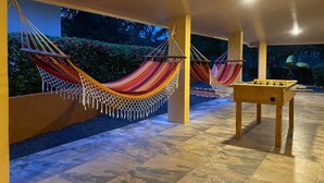 Un espace extérieur aménagé avec deux hamacs et une table de baby-foot.