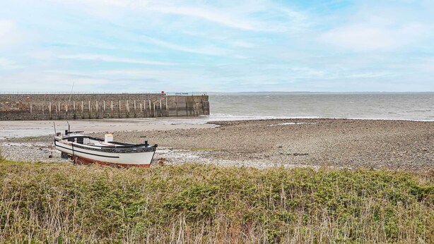 Una playa con un bote y un muelle.