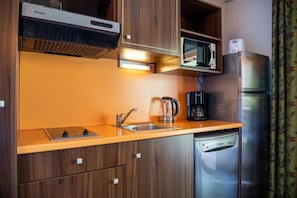 A compact kitchen with a microwave, coffee maker, and a dishwasher. - 1st floor, swimming pool, hammam, terrace, parking, tv, 27m², Pra Loup (Jausiers)