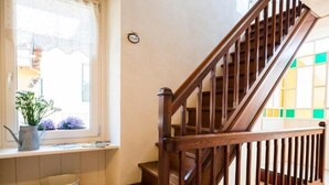 A wooden staircase with a handrail and a window with a lace curtain. - Io&Te wellness space (Sordevolo)