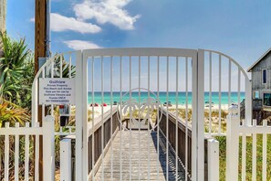 Une entrée fermée par un portail donnant accès à une plage, avec un panneau indiquant qu’il s’agit d’une propriété privée et que l’accès est interdit.