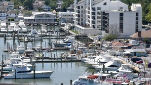 Un port de plaisance où sont amarrés de nombreux bateaux, entouré de bâtiments résidentiels et d’une zone commerciale.