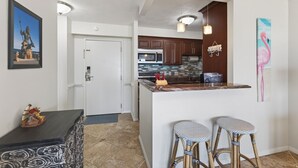 Une cuisine moderne avec un îlot central, des tabourets de bar et un four à micro-ondes.