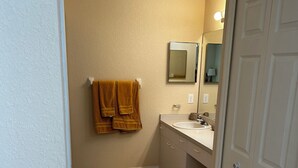 A bathroom with a beige wall, a white door, a white sink, and a mirror above the sink. - HEATED POOL-LANAI-BBQ-5 Mi to BEACH-BICYCLES-TENNIS-GOLF-BLISSFUL RETREAT (Rotonda West)