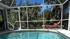 A clear blue pool with a white deck and a red and orange lounge chair. - HEATED POOL-LANAI-BBQ-5 Mi to BEACH-BICYCLES-TENNIS-GOLF-BLISSFUL RETREAT (Rotonda West)