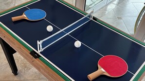 A ping pong table with two paddles and two balls, set on a tiled floor. - HEATED POOL-LANAI-BBQ-5 Mi to BEACH-BICYCLES-TENNIS-GOLF-BLISSFUL RETREAT (Rotonda West)