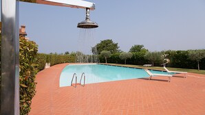 A swimming pool with a water fountain, two sun loungers, and a brick pathway. - Regarda - Miralago 2, bike apartment with pool, lake view, garage (Lazise)