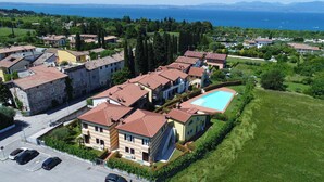 A residential area with multiple houses, a swimming pool, and a view of the sea. - Regarda - Miralago 2, bike apartment with pool, lake view, garage (Lazise)